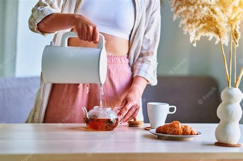 Premium Photo Woman Pouring Boiling Water Into A Cup From Modern