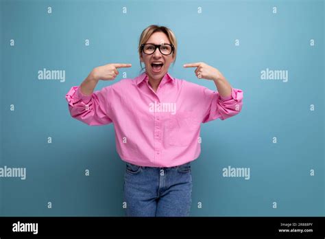 jeune femme blonde blanche bien soignée employée de bureau vêtue d une chemise rose et d un