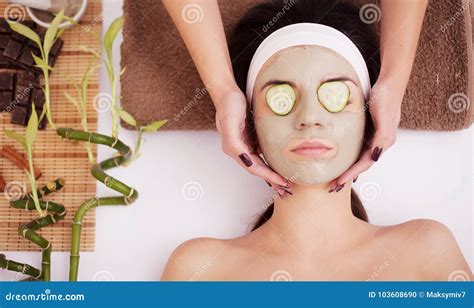 Beautiful Young Woman Is Getting Facial Clay Mask At Spa Lying With