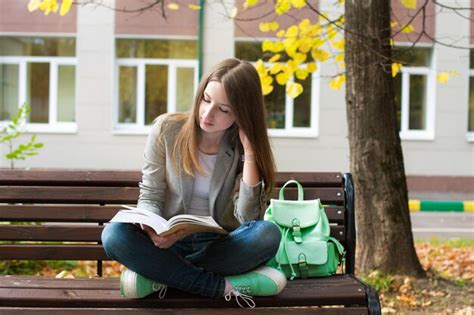 Premium Photo Woman Reading Book While Sitting On Bench Against Trees