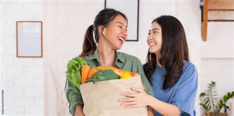Happy Asian Couple Lesbian Holding Vegetable Bag Looing At Camera After