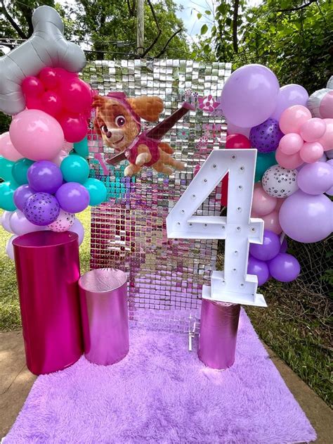 The Balloon Arch Is Decorated With Pink And Purple Balloons