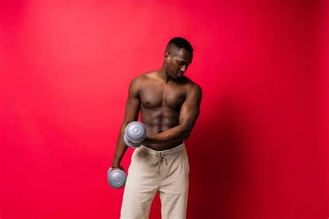 Premium Photo Shirtless Man Lifting Dumbbell Against Yellow Background