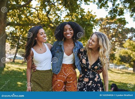 Portrait Of A Group Of Happy Three Diverse Young Women Hugging Laughing