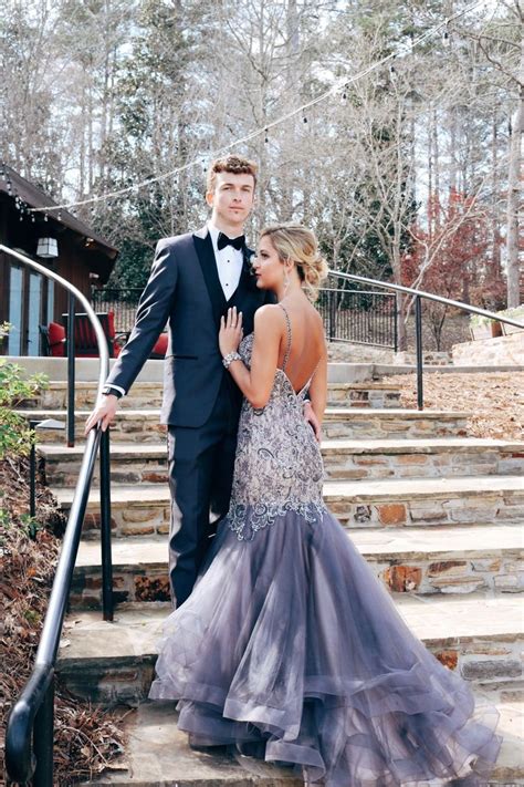 A Man And Woman In Formal Wear Standing On Steps