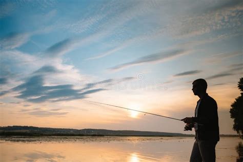 Pesca Girar Al Atardecer Silueta De Un Pescador Imagen De Archivo