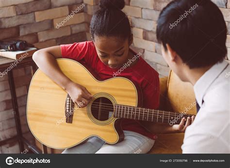 Male Tutor Teaching Black Girl To Play Guitar Stock Photo By