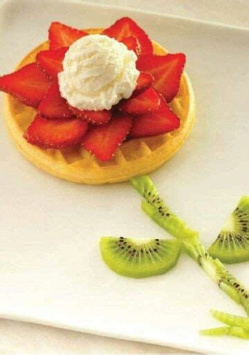 A Waffle Topped With Whipped Cream And Sliced Kiwis On A White Plate