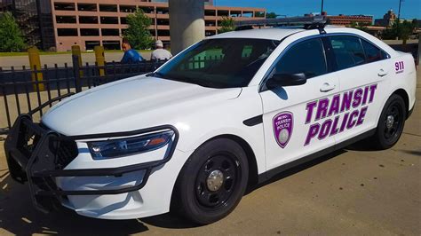 A Transit Police Car Parked In Front Of A Fence