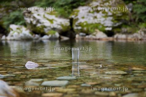 綺麗な川に置かれた水の入ったグラスの写真素材 [193344522] イメージマート