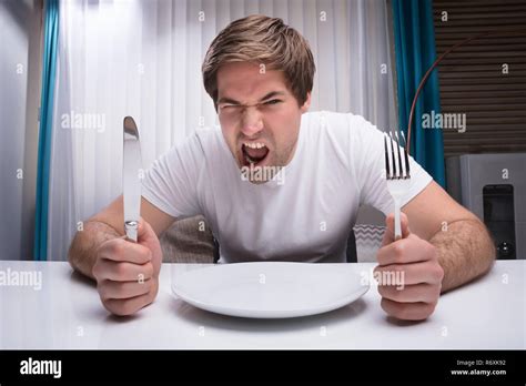 Angry Man Holding Knife And Fork Stock Photo Alamy