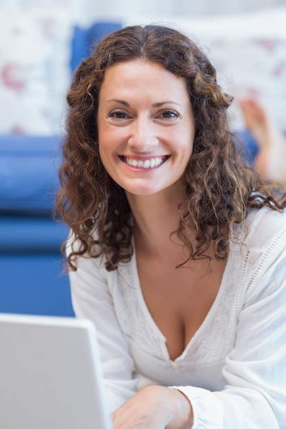 Premium Photo Smiling Woman Lying On The Floor And Using Her Laptop