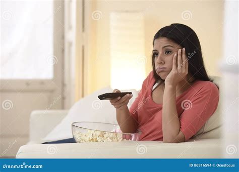 Young Beautiful Woman At Home Watching Television Tired And Bored Stock