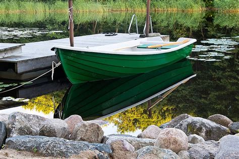 Green Rowboat Near Dommy Stone Lake Mirror Photo Background And Picture