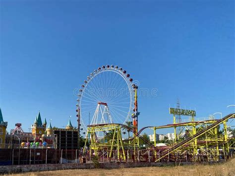 Ferris Wheel And Roller Coaster Rides At Pier Pacific Park At Sunset