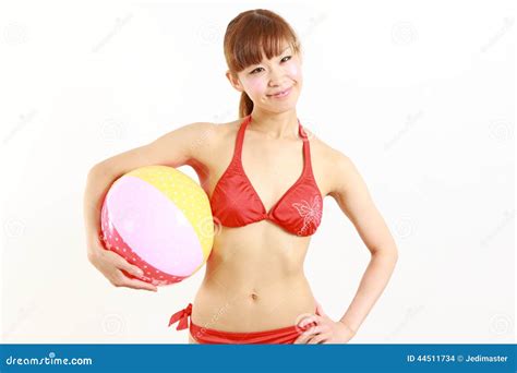 Bikini Que Lleva De La Mujer Japonesa Joven Con La Pelota De Playa Foto