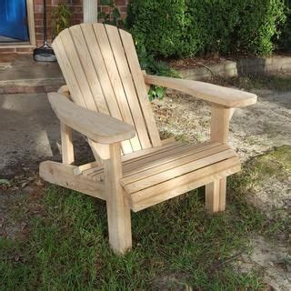 A Wooden Chair Sitting In The Grass Outside