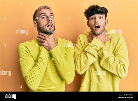Homosexual Gay Couple Standing Together Wearing Yellow Clothes Shouting And Suffocate Because