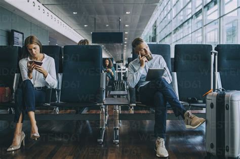 Thoughtful Businessman Looking Away While Sitting By Female Colleague