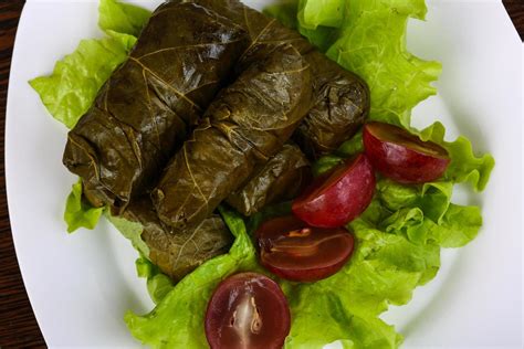 Dolma on the plate and wooden background 12474315 Stock Photo at Vecteezy