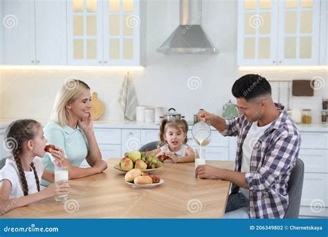 Familia Feliz Comiendo Juntos En La Mesa En Cocina Moderna Foto De