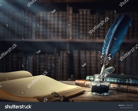 Old Quill Pen Books And Vintage Inkwell On Wooden Desk In The Old