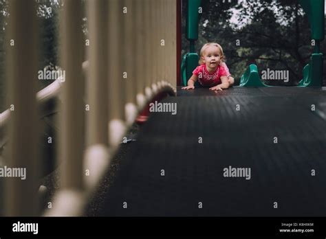 Portrait of baby girl on slide at playground Stock Photo - Alamy