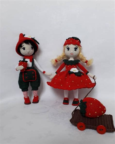 Two Knitted Dolls Are Standing Next To Each Other On A White Surface