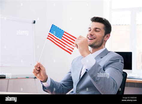 Cheerful handsome businessman holding USA flag in office Stock Photo ...