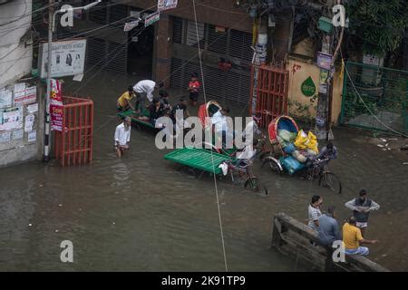 Rickshaw Owners Struggle To Wade Through A Waterlogged Street Following