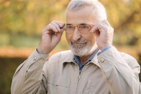 Premium Photo Close Up Of Handsome Bearder Elderly Man Put On Glasses