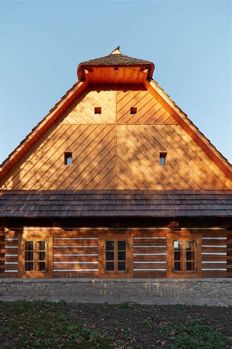 A Large Wooden Building Sitting On Top Of A Grass Covered Field Next To