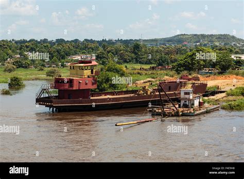 South America, Venezuela, Orinoco River. Tug and boat loading supplies ...