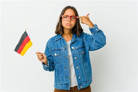 Jovem mulher latina segurando uma bandeira alemã isolada no branco