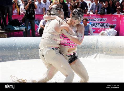 Two Chinese Women Wrestle In A Mud Pool During An Interntional Womens Mud Wrestling Contest