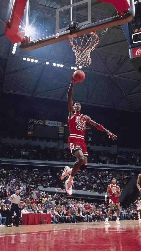 a basketball player dunking the ball in front of an arena full of ...