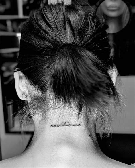 A Woman With A Tattoo On Her Back Neck