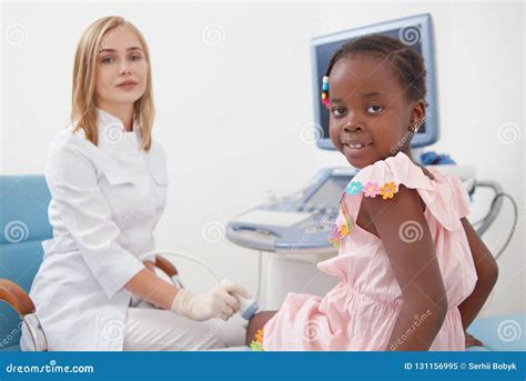 La Fille Afro Mignonne S Asseyant Sur Le Lit Pendant Examine Des