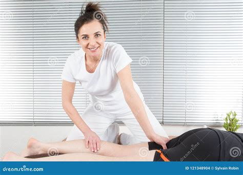 Woman Therapist Working With Patient Male Massaging Leg Calves Stock