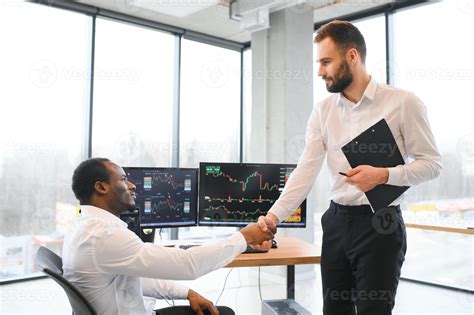 Two happy successful excited diverse traders investors giving high five
