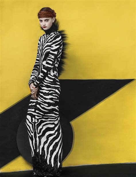 A Woman In Zebra Print Dress Standing Next To A Yellow And Black Wall