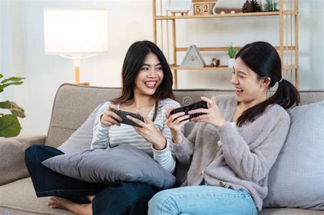 Happy Woman Lesbian Gay Lgbt Couple Enjoying Fun Gaming Session On The Couch At Home Lgbt