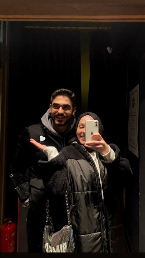 A Man And Woman Taking A Selfie In Front Of A Mirror With Their Cell Phone