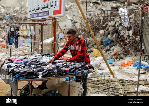 A Palestinian Street Vendor Displays Clothes For Sale Next To The