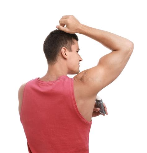 Young Man Applying Deodorant To Armpit On Background Stock Image