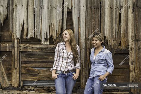 Two Young Women Standing Outside Barn Smiling — Relaxation Hand In