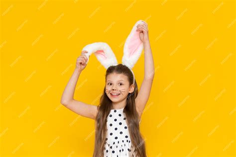 Premium Photo A Beautiful Girl In An Easter Bunny Costume Points At The Advertisement And Smiles