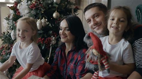 Happy family celebrates Christmas at home. The young family sits on the ...