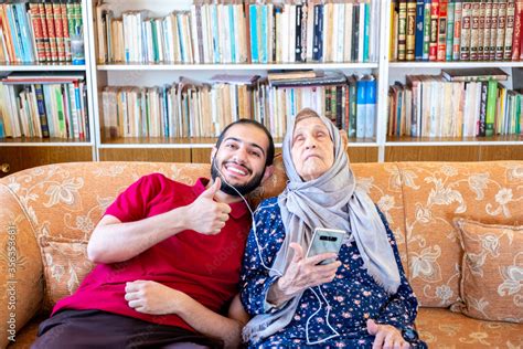 Happy Arabic Muslim Grand Mother And Her Son Sitting Together On Stock