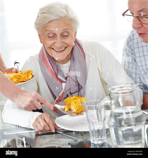 Happy Senior Citizen Couple Eating Lunch In Nursing Home Stock Photo